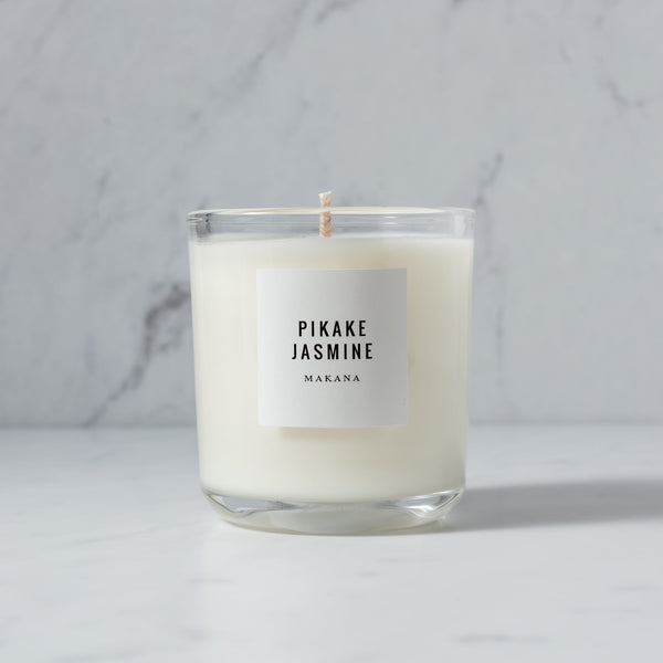 A Makana Pikake Jasmine Classic Candle - NO PACKAGING with 100% soy wax and the word "jasmine" on it.